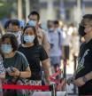 Personas con mascarilla esperan en fila para las pruebas de COVID-19 en Beijing