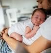 Father holding his baby boy who is falling asleep