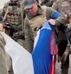 Un grupo de soldados en Kozacha Lopan, región de Járkiv, rasgando una bandera rusa, esta semana