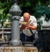 Un hombre refrescándose en la Plaza Catalunya de Barcelona
