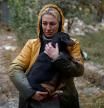 A woman carries a dog at the site of a residential building heavily damaged by a Russian missile strike, amid Russia’s attack on Ukraine, in Mykolaiv, Ukraine October 18, 2022. REUTERS/Valentyn Ogirenko