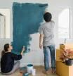 Young asian couple painting interior wall with paint roller in new house