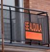 Un cartel anunciando un alquiler en el balcón de un piso