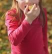 Girl in an orchard eating apple