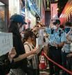 HONG KONG, CHINA - NOVEMBER 28: People hold signs in protest of COVID restriction in mainland as police setup cordon during a vigil in the central district on November 28, 2022 in Hong Kong, China. Protesters took to the streets in multiple Chinese cities after a deadly apartment fire in Xinjiang province sparked a national outcry as many blamed COVID restrictions for the deaths. (Photo by Anthony Kwan/Getty Images)