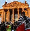 Un manifestant alemany amb una bandera ultra davant del parlament, a Berlín, el 29 d'agost del 2020 (horitzontal)