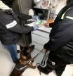 Dos agentes analizan la droga intervenida con la ayuda de un perro
