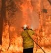 This file photo taken on December 10, 2019 shows a firefighter conducting back-burning measures to secure residential areas from encroaching bushfires in the Central Coast, some 90-110 kilometres north of Sydney. - Climate change is already buffeting Australia with more extreme bushfires, droughts and cyclones -- and the fossil-fuel reliant country should brace for worse to come, according to Australia's top science and weather agencies on November 13, 2020. (Photo by Saeed KHAN / AFP)