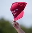 Un seguidor de Trump agita una gorra de su campaña delante de su casa deMar-a-Lago, en Florida