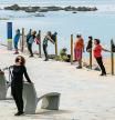 foto XAVIER CERVERA 31/05/2021 un grupo de personas mayores, posiblemente jubilados, practican ejercicios, deporte, estiramientos, en un dia caluroso, con sol, de primavera, en el espigon de bogatell, con la playa d nova icaria de fondo, frente maritimo d barcelona (algunos con mascarilla ,otros no ;cuarta ola pandemia covid) mar mediterraneo