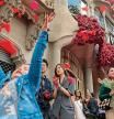 Ambiente en las calles de Barcelona de la Diada de Sant Jordi en la venta de libros y rosas. La casa Batllo decorada con rosas sirve para hacerse selfies a toda la gente que pasea por la fachada. Una niña juega con los pétalos de rosas del suelo, junto al edificio