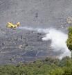 Un avión apaga incendios de la Unidad Militar de Emergencias (UME) vierte agua  sobre el incendio forestal originado en el término municipal de Robledo de Chavela (Madrid), que continúa activo, pero en el que los trabajos realizados durante la noche por los equipos de extinción han logrado estabilizar su perímetro, sin riesgo para las poblaciones cercanas, en Robledo de Chavela, Madrid (España) a 3 de agosto de 2020. Durante esta mañana se están desplegando medios aéreos con descargas de agua de forma continua para intentar que ese perímetro no crezca ni se abran nuevos frentes del fuego. 
