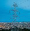 COSTES DE ENERGIA Y SUMINISTROS BÁSICOS.. UNA TORRE DE ELECTRICIDAD CON LA CIUDAD DE BARCELONA DE FONDO
