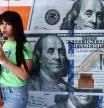 A woman drinks juice next to a currency exchange with United States Dollar bills printed on its windows in Buenos Aires, Argentina, December 12, 2023. REUTERS/Tomas Cuesta