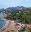 Una imagen de la playa de l'Ampolla en Moraira y la pinada que amenaza un proyecto urbanístico.
