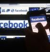 (FILES) In this file photo taken on March 22, 2018 a cellphone and a computer screen display the logo of the social networking site Facebook in Asuncion. Facebook said April 10, 2018 it would begin offering rewards to people who report misuse of private information from the social network, as part of an effort to step up data protection in the wake of a firestorm.The new program 
