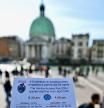 A person shows a calendar of the paying days to visit Venice, on April 19, 2024 in front of Santa Lucia train station in Venice. The new strategy to lower the number of tourists visiting the UNESCO World Heritage site calls for day-trippers to pay a five-euro ticket to enter the historic city centre and is due to start on April 25. The
