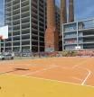 La pista de baloncesto con las Tres Chimeneas del Paral·lel al fondo