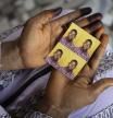 Mariama Sylla, sister of Ousmane Sylla, holds photos of him in their house at Matoto Bonagui, a suburb of Conakry, Guinea, Monday, April 8, 2024. Sylla had landed on Italian shores a year before his death in Feb. 4, 2024, one of tens of thousands of people who pay migrant smugglers hundreds or thousands of euros to cross the Mediterranean to reach Europe. He had no visa, and had been ordered to leave after admitting that he had lied about being a minor. (AP Photo/Misper Apawu)