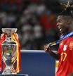 Spain's midfielder #17 Nico Williams celebrates with his silver medal next to the trophy after winning the UEFA Euro 2024 final football match between Spain and England at the Olympiastadion in Berlin on July 14, 2024. (Photo by JAVIER SORIANO / AFP)
