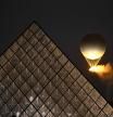 TOPSHOT - The cauldron, with the Olympic flame lit, lifts off while attached to a balloon, during the opening ceremony of the Paris 2024 Olympic Games in Paris on July 26, 2024, as the Louvre Pyramid is seen next to it. (Photo by JUNG Yeon-je / AFP)