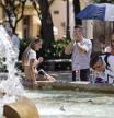 -FOTODELDÍA- GRAFCVA2024. VALENCIA, 24/07/2024.- Un grupo de personas se refresca junto en una fuente durante la mañana de este miércoles cuando la segunda ola de calor de este verano lega en su puntúo álgido cono temperaturas que oscilarán entre los 40-42 grados en más de media España, incluso hasta los 44 grados en puntos de Andalucía y Extremadura. EFE/Ana Escobar