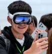An attendee wearing an Apple Vision Pro with the Apple iPhone 16 Pro during an event at Apple Park campus in Cupertino, California, US, on Monday, Sept. 9, 2024. Apple Inc.introduced the latest version of its flagship device, the iPhone 16, betting it can entice consumers with modest hardware upgrades and AI technology that#{emoji}146;s still on the horizon. Photographer: David Paul Morris/Bloomberg
