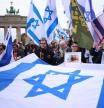 Berlin (Germany), 06/10/2024.- Participants walk with Israeli flags in front of the Brandenburg Gate during a rally to call for the release of the Israeli hostages held in Gaza, in Berlin, Germany, 06 October 2024. According to a statement by the Israeli Government Press Office, 97 Israeli hostages remain in captivity in the Gaza Strip, including bodies of 33 confirmed dead. Upcoming 07 October 2024 marks one year since the Palestinian militant group Hamas launched a surprise attack on Israel, killing 1,200, and one year since Israel began its war on Gaza, killing more than 41,000 and destroying the Palestinian enclave. (Protestas, Alemania) EFE/EPA/CLEMENS BILAN