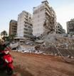 A man rides his moped past destroyed buildings at the site of an overnight Israeli airstrike that targetted a branch of the Al-Qard Al-Hassan finance group in Beirut#{emoji}146;s southern suburbs on October 21, 2024, amid the ongoing war between Israel and Hezbollah. Israel began bombing Lebanese branches of an association accused of financing the Iran-backed Hezbollah movement, Lebanese state media reported late on October 20, in a further escalation of Israel's nearly month-long war against the militants. (Photo by IBRAHIM AMRO / AFP)