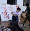 People try to clean the street covered in debris and mud near a banner reading 'Thank you, the People save the People' in Sedavi, south of Valencia, eastern Spain, on November 5, 2024, following devastating flooding. Spain announced an aid package worth 10.6 billion euros ($11.5 billion) to rebuild regions devastated by its worst floods in a generation that have killed 219 people. (Photo by JOSE JORDAN / AFP)