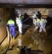 Los operarios trabajan en la extracción de lodo de un garaje afectado por la DANA.