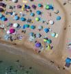 Numerosas personas disfrutan de un día de playa en la Costa Brava, a 30 de julio de 2023, en Tossa de Mar, Girona, Cataluña (España). Las playas españolas se llenan  de turistas para paliar el calor. De acuerdo con la información de la Agencia Estatal de Meteorología, los veranos en España se han ido calentando desde los años 80, con olas de calor cada vez más comunes e intensas. Los veranos son cada vez más largos, durando cinco semanas más y aumentando a un ritmo de nueve días por década.