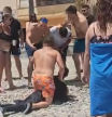Un bañista inmoviliza a un migrante en la playa