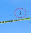 Un activista de Greenpeace camina sobre una cuerda a 30 metros de altura en Madrid ante el inicio de la COP30