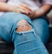 Una joven con un pantalón tejano roto.