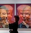 A visitor stands near an art installation portraying China's President Xi Jinping, U.S. President Donald Trump and Russia's President Vladimir Putin during the ARTSUBS exhibition in Surabaya on August 2, 2025. (Photo by Juni KRISWANTO / AFP) / RESTRICTED TO EDITORIAL USE - MANDATORY MENTION OF THE ARTIST UPON PUBLICATION - TO ILLUSTRATE THE EVENT AS SPECIFIED IN THE CAPTION