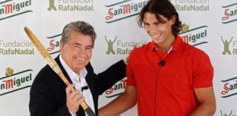 El ex tenista Manolo Santana sostiene una raqueta junto al número uno mundial, Rafa Nadal, en el Real Club de Tenis de Barcelona