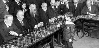 Un niño prodigio del ajedrez, Samuel Reshevsky, de ocho años, se enfrenta a varios maestros del ajedrez, en unas partidas simultáneas en Francia en 1920.
