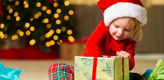 Una niña abre su regalo de navidad.