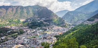 Andorra la Vella City Center of the capital city of Andorra in between Pyrenees. Panorama City View from above into the valley with surrounding Pyrenees Mountains, Andorra is a tiny independent principality situated between France and Spain in the Pyrenees mountains. It’s known for its ski resorts, and a tax-free status and duty free shopping. Andorra La Vella, Pyrenees, Andorra, Southern Europe