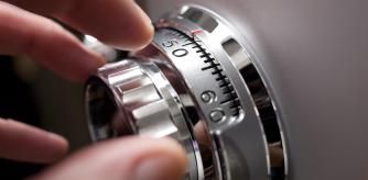 Mano abriendo una caja fuerte con combinación.