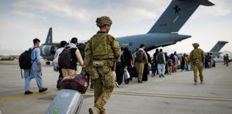 Un grupo de afganos embarcan en un avión australiano en Kabul