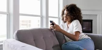 Mujer relajándose en el sofá con su smartphone