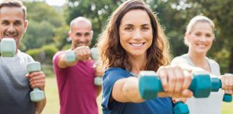 Un grupo de personas hacen ejercicio con pesas