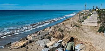 foto XAVIER CERVERA 26/05/2022 una familia de el prat de llobregat en la playa q se ha quedado en algunas zonas sin arena.. por el cambio climatico (tres mujeres y dos ninos sobre la zona d tierra, y tras las piedras grandes, ya no hay playa...) El Prat de Llobregat lamenta l'estat de regressió del litoral del Delta del Llobregat, de la seva platja, i urgeix actuacions. Demà a les 11:30 fan una roda de premsa a la platja de Can Camins. Si és possible fer la roda de premsa i prendre imatges de la platja.