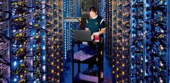 Una emprleada de Google revisa una CPU en uno de los centros de datos de la compañía en The Dalles (Oregon)