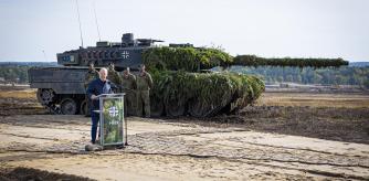FILE - German Chancellor Olaf Scholz speaks to soldiers in front of a Leopard 2 main battle tank after the Army's training and instruction exercise in Ostenholz, Germany, Monday, oct. 17, 2022. Germany has become one of Ukraine's leading weapons suppliers in the 11 months since Russia's invasion. The debate among allies about the merits of sending battle tanks to Ukraine has focused the spotlight relentlessly on Germany, whose Leopard 2 tank is used by many other countries and has long been sought by Kyiv. (Moritz Frankenberg/dpa via AP, FILE)