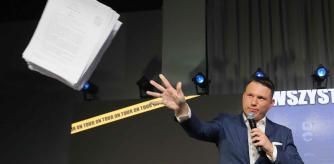 El colíder del partido Confederación, Slawomir Mentzen, de 36 años, arrojando unos papeles en un encuentro electoral en Varsovia el 7 de octubre