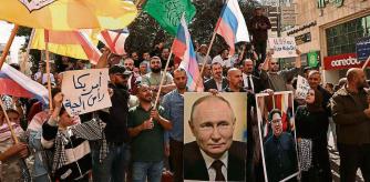 People wave Russian, Palestinian, Fatah and Hamas flags, and carry portraits of Russia's President Vladimir Putin and North Koren leader Kim Jong Un, as they take to the streets of the occupied West Bank city of Hebron to show solidary with the Palestinians of the Gaza Strip on October 20, 2023, amid ongoing battles between Israel and the Hamas movement. (Photo by HAZEM BADER / AFP)