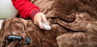 Una persona con una manta eléctrica a pilas.